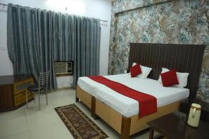 a bedroom with a bed and a desk and a television at Mansarover Hotel & Banquets in Bareilly