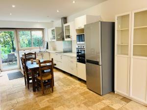 a kitchen with a table and a stainless steel refrigerator at Le Relais des Anges in Mercuès