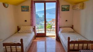 two beds in a room with a view of the ocean at Apartments Sijerkovic in Herceg-Novi