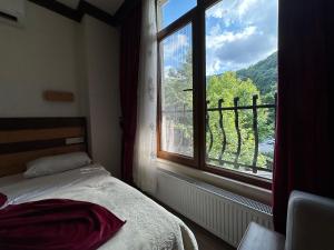 a bedroom with a bed and a large window at Mersu Ala Konak Otel maşukiye sapanca in Kocaeli