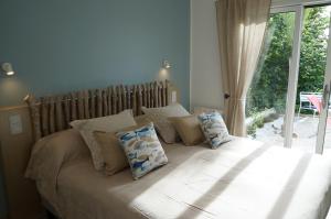 um quarto com uma cama com almofadas e uma janela em Vacation Home - Maison de vacances em Saint-Xandre