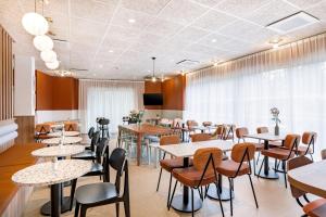 a restaurant with tables and chairs and a tv at Kyriad Lyon Est Stadium Eurexpo Meyzieu in Meyzieu