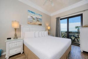 a bedroom with a white bed and a large window at Phoenix VI 6104 in Orange Beach +63 photos