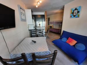 a living room with a table and a blue couch at Altissim Grizzly in Pas de la Casa