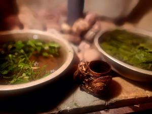 ein Tisch mit drei Schüsseln Suppe und grünem Gemüse in der Unterkunft Pie omītes in Ventspils