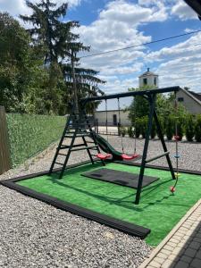 a swing set in a yard with green grass at Texaco in Kazimierz Dolny