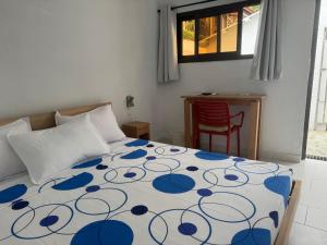 a bedroom with a bed with a blue and white bedspread at Maison Mimosa in Grand-Bassam +48 photos