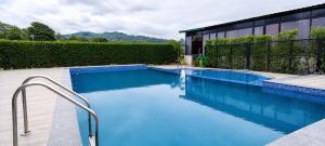 a swimming pool with blue water in front of a building at Vasant Corbett Resort By Mannat in Rāmnagar