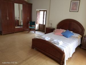 a bedroom with a large bed with blue and pink pillows at La Chungita in Villanueva de Arosa