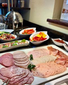 a table with many different types of meats and vegetables at Hotel Angerbräu in Murnau am Staffelsee