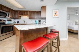 a kitchen with a counter and two stools at Phoenix VI 6312 in Orange Beach