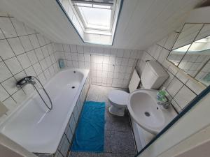 a bathroom with a toilet and a tub and a sink at Vous êtes bienvenue in Ramstein-Miesenbach +5 photos