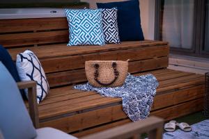 a group of pillows sitting on a wooden bench at Urban Living Homes, with Jaccuzi in Agios Onoufrios