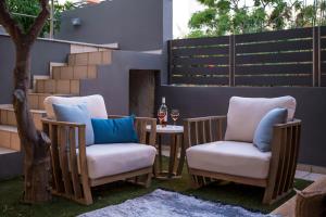 two chairs and a table with a glass of wine at Urban Living Homes, with Jaccuzi in Agios Onoufrios
