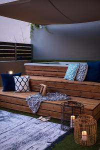 a large wooden bed with many pillows on it at Urban Living Homes, with Jaccuzi in Agios Onoufrios