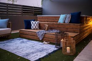a wooden couch sitting on the grass in a yard at Urban Living Homes, with Jaccuzi in Agios Onoufrios