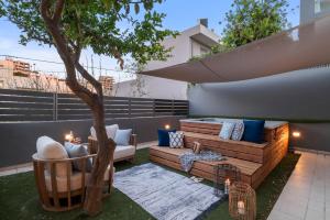 a patio with a couch and a tree at Urban Living Homes, with Jaccuzi in Agios Onoufrios +77 photos