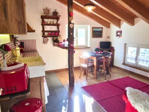 a kitchen with a table and a dining room at B&B Ca' La Vedescia in Teglio