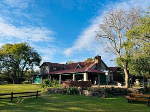 a house in a park with benches in the grass at BelofteBos Farmhouse Inn in Bandelierkop