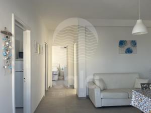a white living room with a white couch and a hallway at La Torre - Piano Primo By Cala Salento in Torre Lapillo