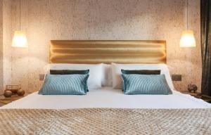 a bedroom with a bed with two blue pillows at Villa Birdie Boutique - Adults Only in Donostia-San Sebastián +40 photos