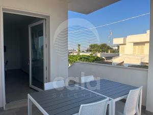 a table and chairs on a balcony with a view of the city at La Torre - Piano Primo By Cala Salento in Torre Lapillo