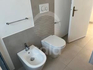 a bathroom with a white toilet and a sink at La Torre - Piano Primo By Cala Salento in Torre Lapillo +21 photos