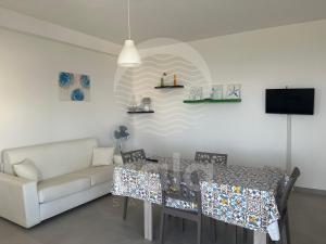 a living room with a table and a couch at La Torre - Piano Primo By Cala Salento in Torre Lapillo