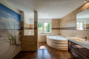 a large bathroom with a tub and a sink at Seemannshus in Born +29 photos