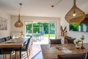 a dining room with a wooden table and chairs at Seemannshus in Born