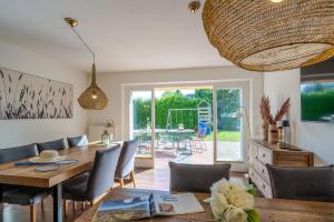 a dining room with a wooden table and chairs at Seemannshus in Born