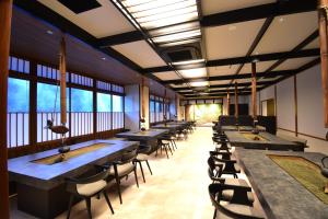 a row of tables and chairs in a room with windows at Hotel Kazurabashi in Miyoshi