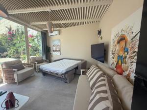 a living room with a couch and a tv at Villa RRE Green Coast in Palasë