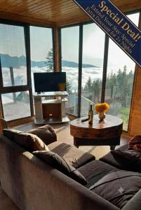 a living room with a couch and a table and a large window at GomisMta-Luxury Cottage with Panor in Gomi