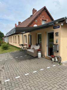 a house with a patio with a couch and a table at SchrauberStube Bertkow in Goldbeck