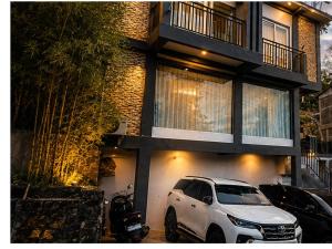 a white suv parked in front of a building at Teupin Layeu Hotel in Iboih