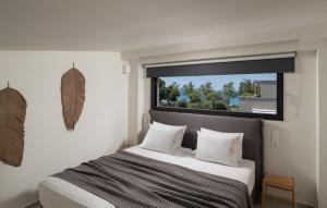 a bedroom with a bed with a large window at Villas THALLO in Paradisos +85 photos