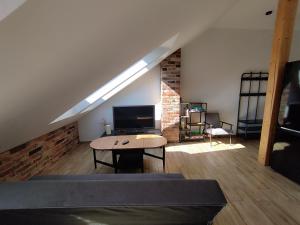 a room with a couch and a table in a loft at Apartament Karmelicka in Wadowice