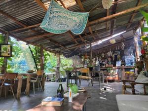 a room with tables and chairs and a light fixture at Backyard Eco Bungalows Moshi in Moshi