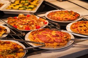 a bunch of pizzas on plates on a table at Argisht Partez Hotel ALL INCLUSIVE & BEACH BAR REBLS in Golden Sands +120 photos