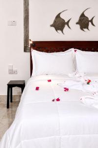a bedroom with a white bed with flowers on it at The lagoons resort Zanzibar in Nungwi