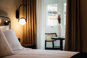 a hotel room with a bed and a vase of flowers on a table at Royale Sainte Hélène Boutique Hotel in Birkirkara