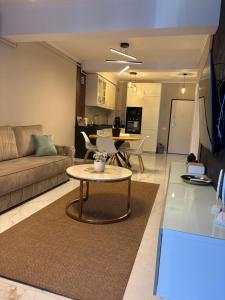a living room with a couch and a table at F&L Relax Mamaia Nord -Apartament cu parcare gratuită in Mamaia Sat/Năvodari