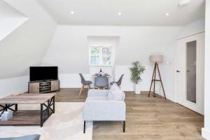 a living room with a couch and a tv at Addenbrookes Apartment in Trumpington