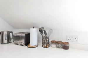 a kitchen counter with a toaster and some utensils at Addenbrookes Apartment in Trumpington