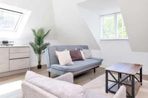 a living room with a blue couch and a table at Addenbrookes Apartment in Trumpington