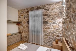 a bedroom with a stone wall at Garden Residence in Ermoupoli