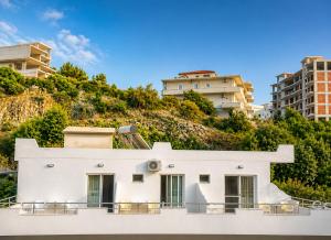 a white house on a hill with buildings at Keivi Guesthouse in Sarandë