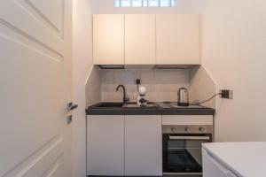 a small kitchen with white cabinets and a sink at dream house in Olbia