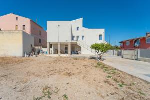 a large white building sitting on top of a dirt field at dream house in Olbia